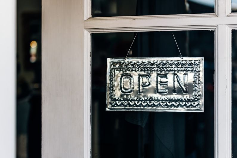 Reopenings - black and white wooden welcome signage