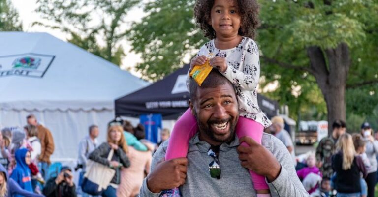 Parade - Girl Sitting on Smiling Man's Shoulder