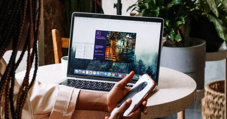 Premieres - Person Holding Iphone 6 Near Macbook Pro