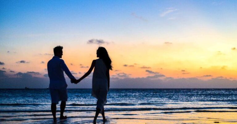 Anniversary - Man and Woman Holding Hands Walking on Seashore during Sunrise